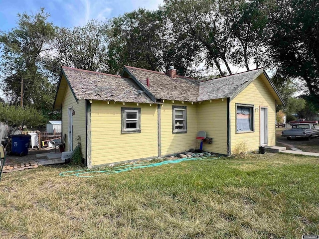 back of house featuring a lawn