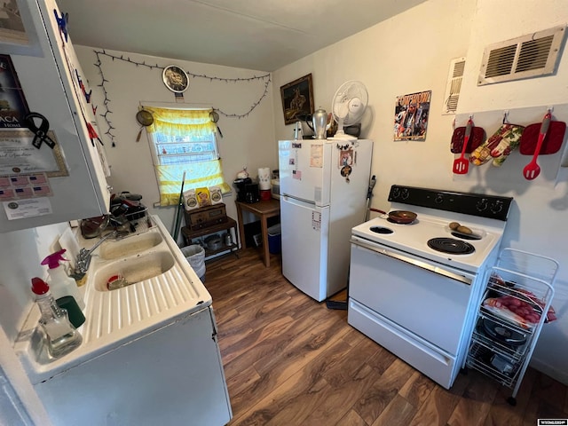 kitchen featuring white appliances and dark hardwood / wood-style flooring