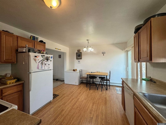 kitchen with light wood-type flooring, white appliances, an inviting chandelier, hanging light fixtures, and a baseboard heating unit