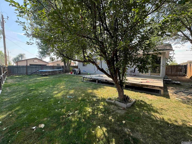 view of yard with a wooden deck and a trampoline