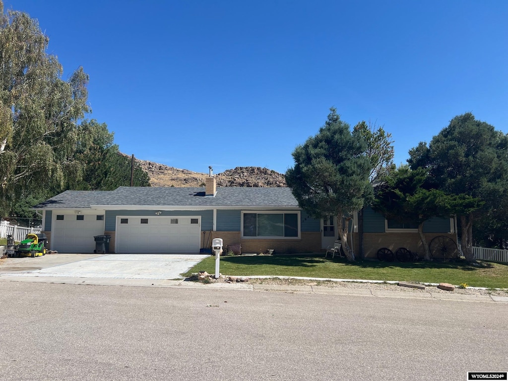 ranch-style home with a front lawn and a garage