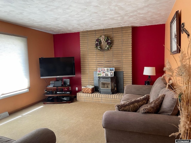 living room with carpet, a wood stove, and a textured ceiling