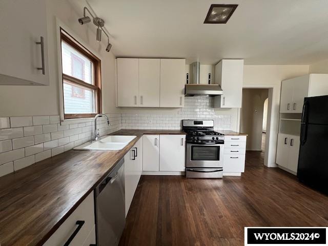 kitchen with white cabinetry, stainless steel appliances, wooden counters, sink, and dark hardwood / wood-style floors