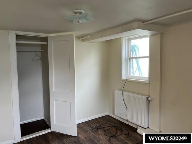 interior space with radiator, dark hardwood / wood-style flooring, and a closet