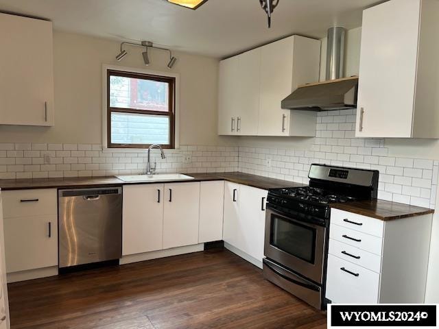 kitchen featuring backsplash, stainless steel appliances, sink, dark hardwood / wood-style floors, and white cabinets