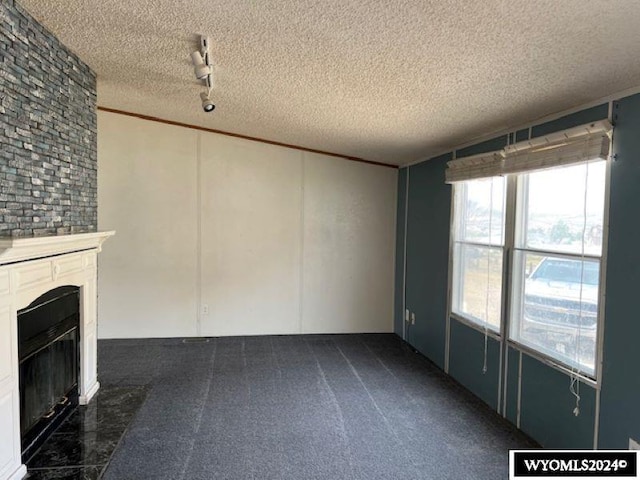 156 Elm St, Kemmerer, WY 83101 - unfurnished living room featuring a textured ceiling and a glass covered fireplace