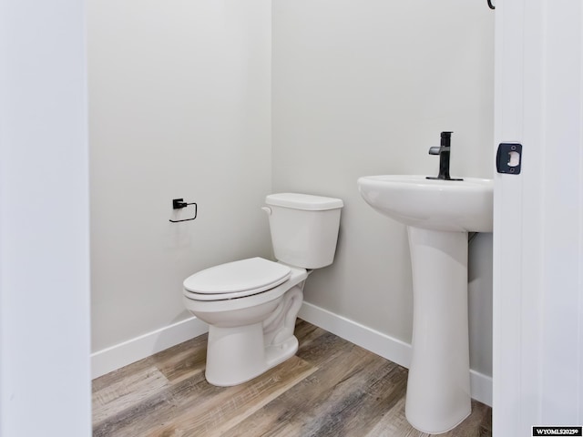 bathroom featuring wood-type flooring and toilet