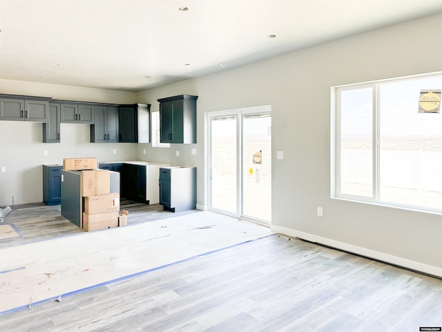 kitchen with gray cabinetry and light hardwood / wood-style floors