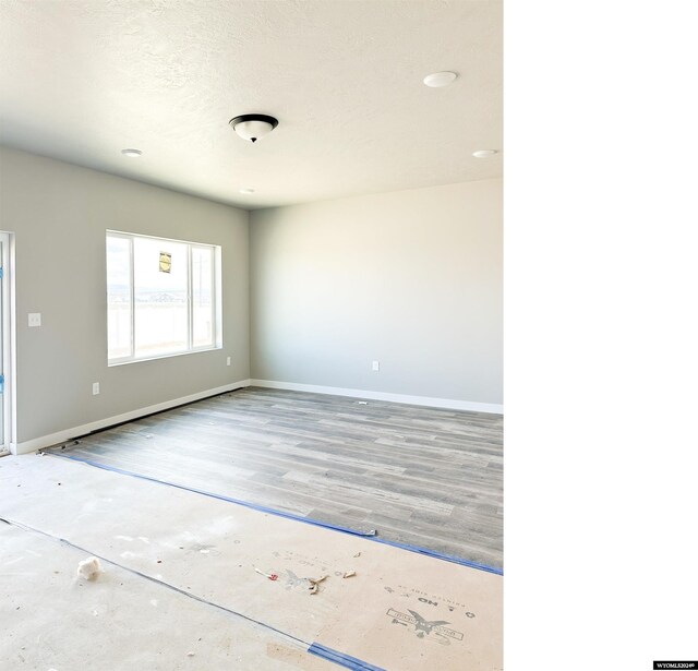 bathroom with wood-type flooring, shower / washtub combination, and a textured ceiling