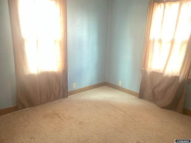 carpeted spare room with a healthy amount of sunlight