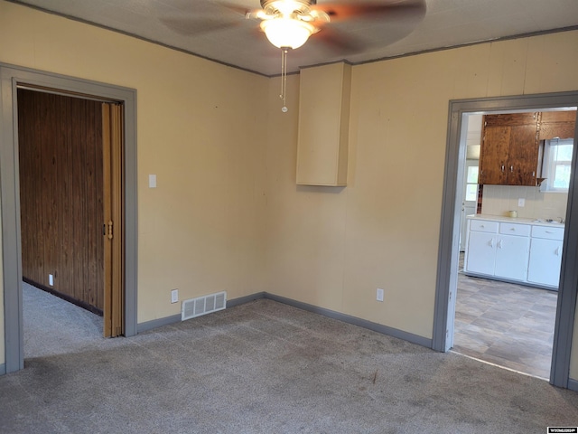 unfurnished room with ceiling fan and light carpet