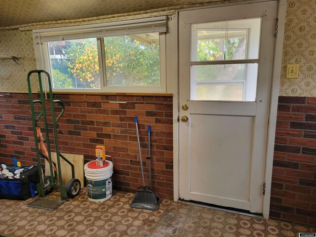 doorway featuring brick wall