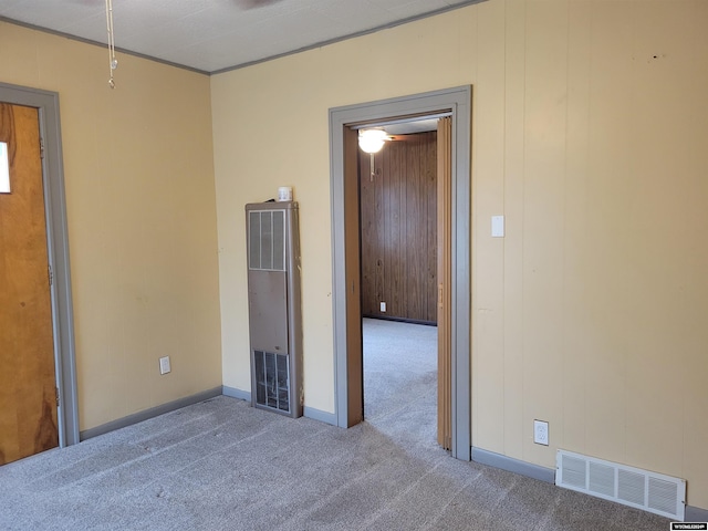 spare room featuring carpet and wooden walls