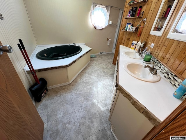 bathroom with a bath, wood walls, and vanity