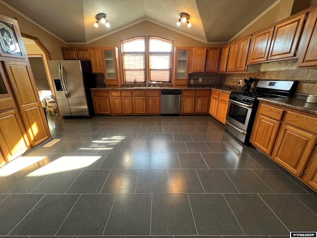 kitchen with ornamental molding, stainless steel appliances, sink, decorative backsplash, and lofted ceiling