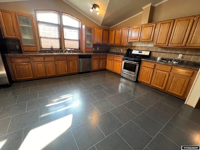 kitchen with a textured ceiling, backsplash, stainless steel appliances, sink, and lofted ceiling