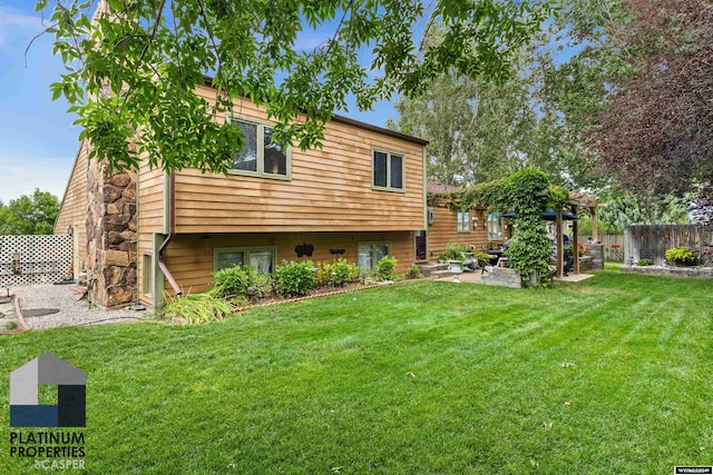 rear view of house with a lawn and a patio