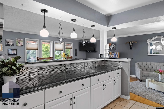 kitchen featuring white cabinets, hanging light fixtures, and light tile patterned floors