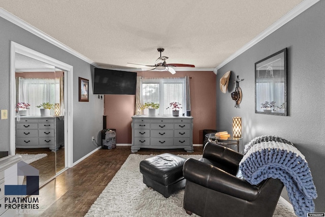 living area featuring a textured ceiling, dark wood-type flooring, ceiling fan, and ornamental molding