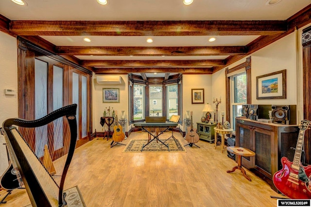 rec room featuring beamed ceiling, light hardwood / wood-style flooring, and a wall mounted air conditioner