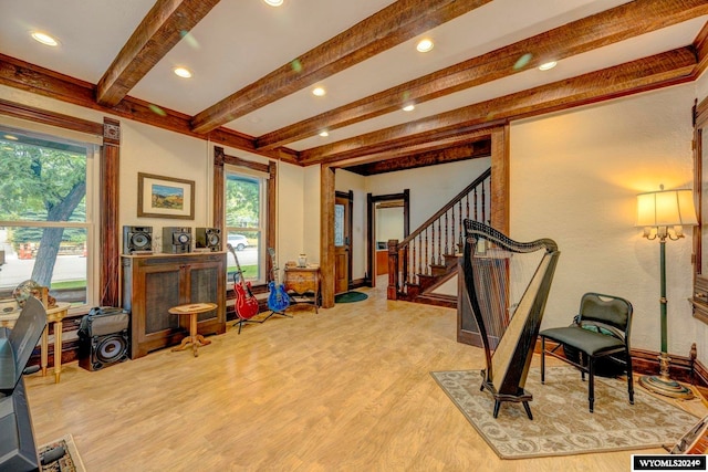 interior space with light wood-type flooring and beam ceiling