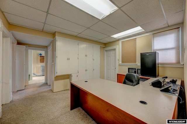 office featuring a paneled ceiling, light carpet, and radiator heating unit