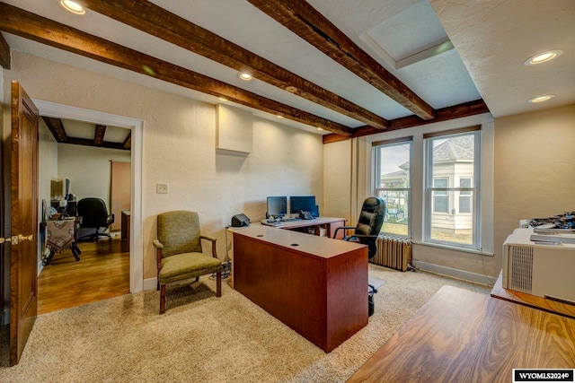 office space featuring radiator heating unit, light wood-type flooring, and beam ceiling