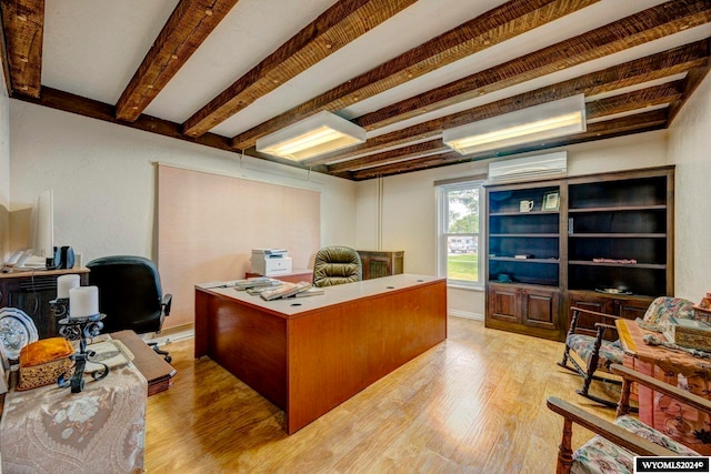 office area featuring light hardwood / wood-style flooring, a wall unit AC, and beam ceiling