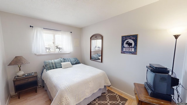 bedroom featuring wood-type flooring and a textured ceiling