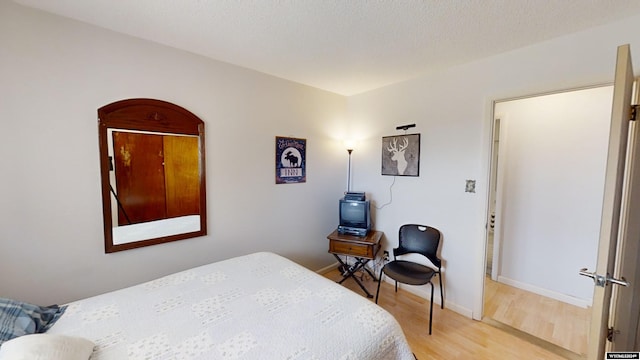 bedroom featuring wood-type flooring and a textured ceiling