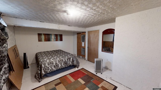 bedroom featuring a textured ceiling and radiator