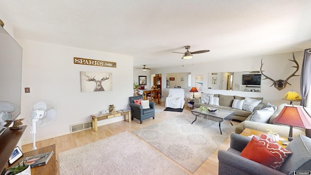 living room featuring wood-type flooring and ceiling fan