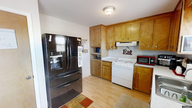 kitchen featuring sink, light hardwood / wood-style floors, and black appliances