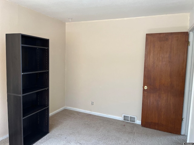 unfurnished room featuring light colored carpet