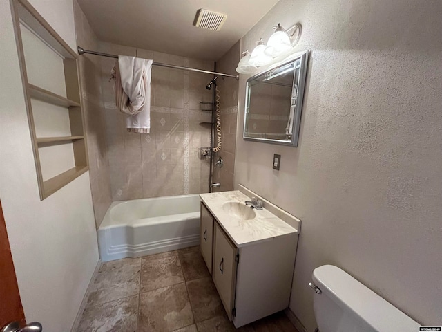 full bathroom with tiled shower / bath combo, tile patterned flooring, vanity, and toilet