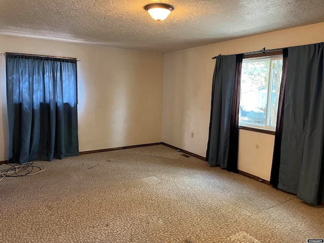 carpeted empty room featuring a textured ceiling