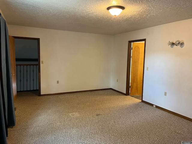 carpeted empty room with a textured ceiling