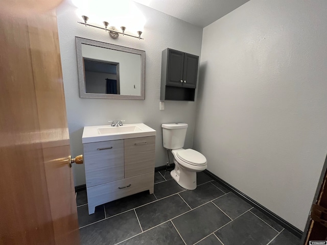 bathroom with tile patterned flooring, vanity, and toilet