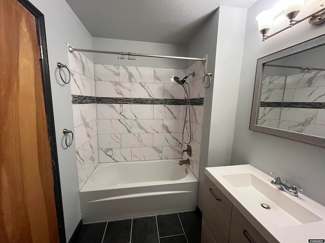 bathroom featuring a textured ceiling, vanity, tile patterned floors, and tiled shower / bath