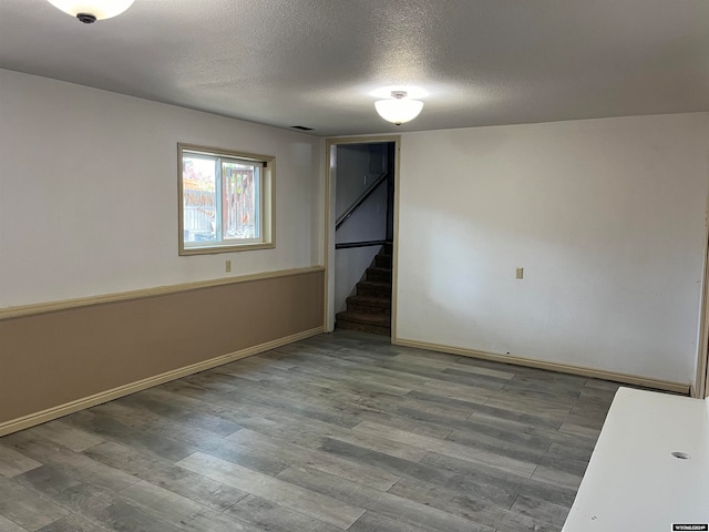 unfurnished room featuring a textured ceiling and hardwood / wood-style floors