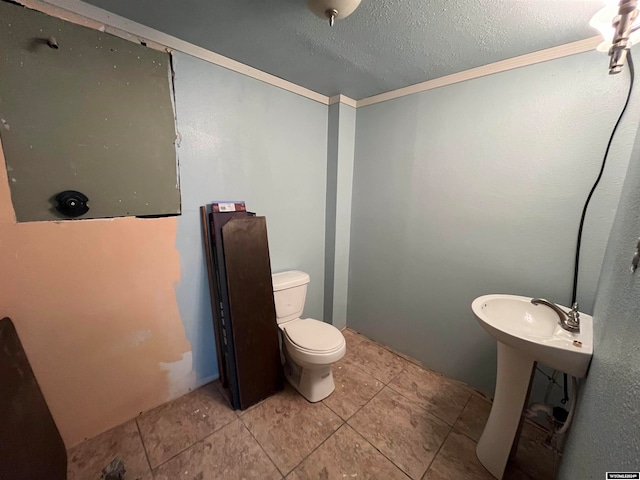 bathroom with crown molding, toilet, and tile patterned floors