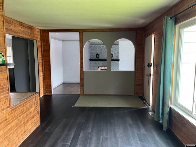 unfurnished room featuring wooden walls and dark hardwood / wood-style flooring