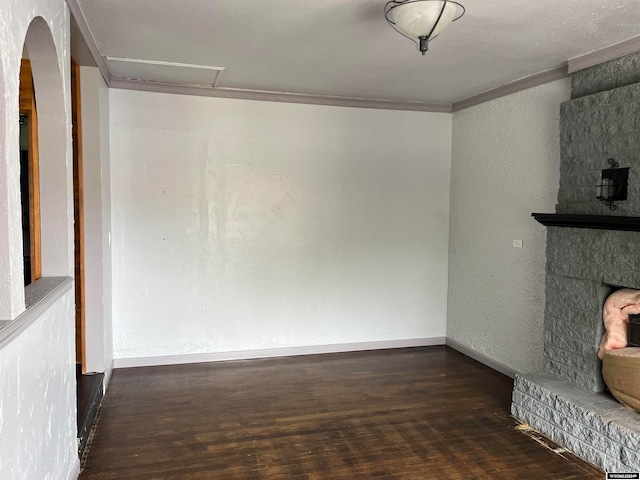 unfurnished living room featuring crown molding and dark wood-type flooring