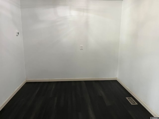 unfurnished room with dark wood-type flooring