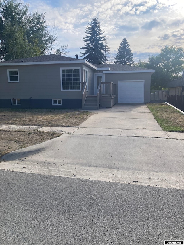 view of front facade featuring a garage, fence, and concrete driveway