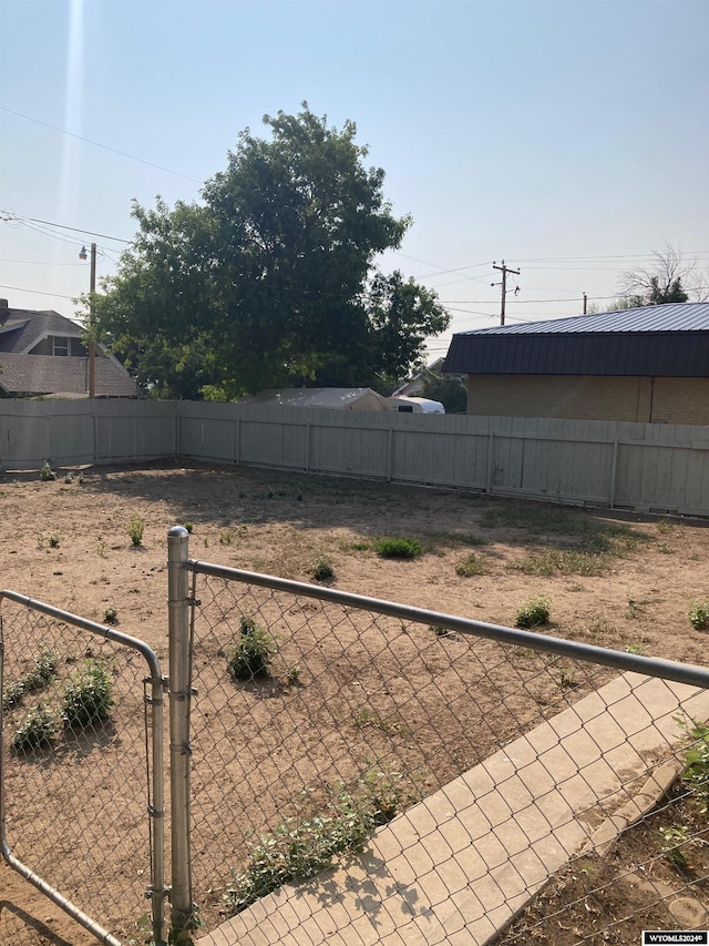 view of yard featuring a fenced backyard and a gate