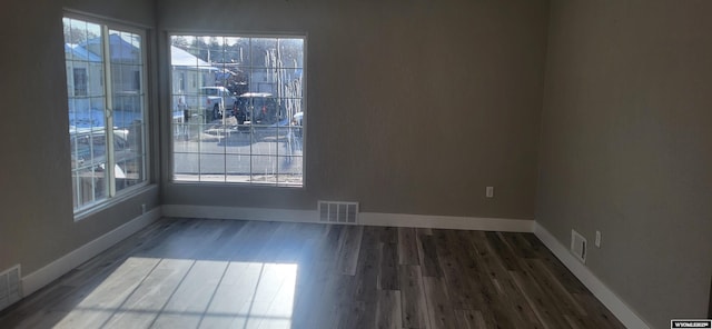 unfurnished dining area with wood finished floors, baseboards, and visible vents