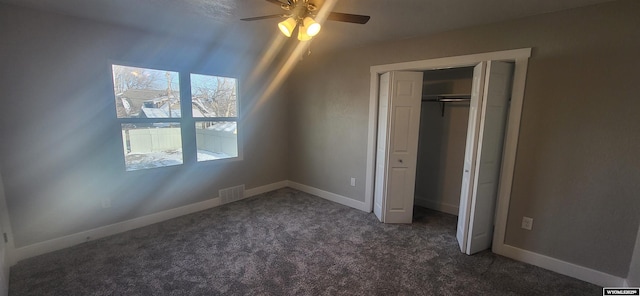 unfurnished bedroom with a closet, baseboards, dark carpet, and visible vents