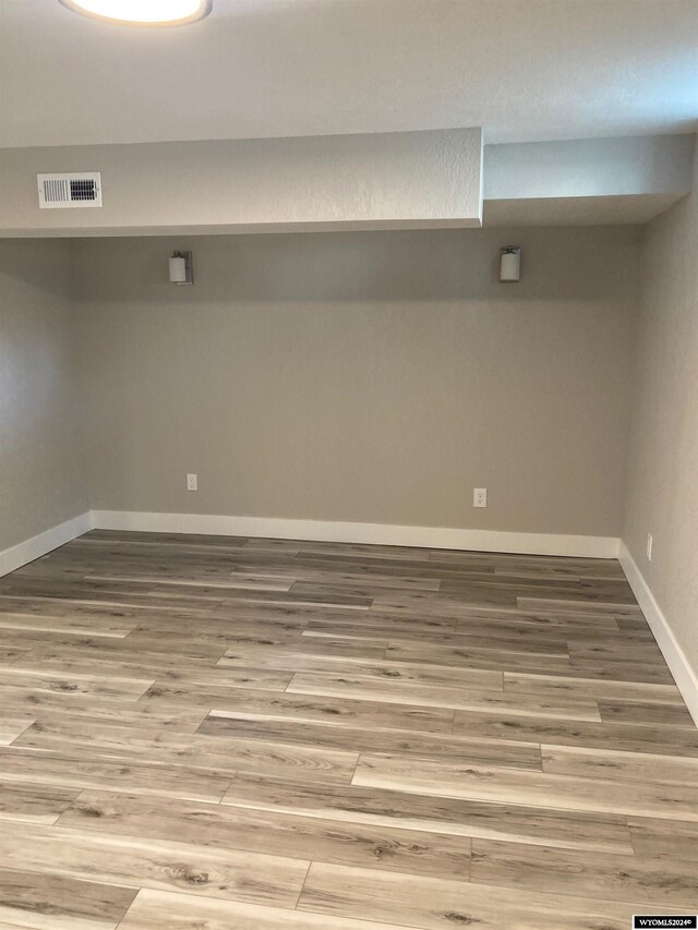 basement with hardwood / wood-style flooring