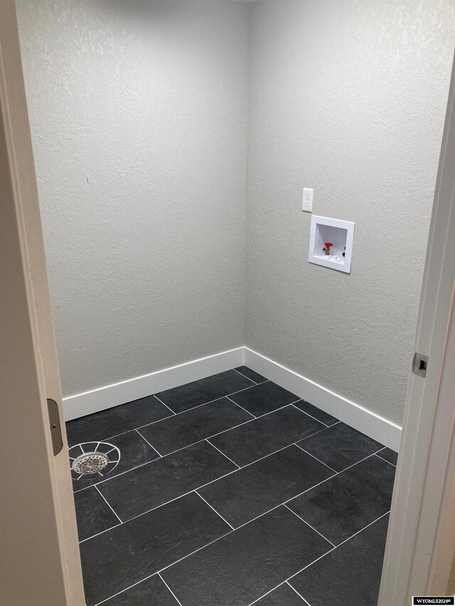 laundry area with washer hookup and dark tile patterned floors